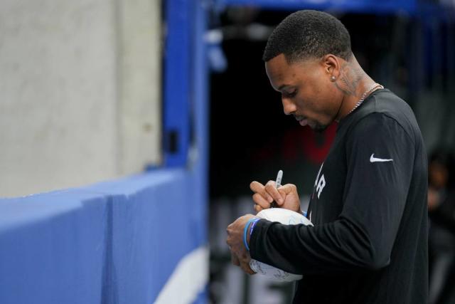 Jan 8, 2023; Indianapolis, Indiana, USA; Indianapolis Colts cornerback Isaiah Rodgers Sr. (34) signs a ball for a fan Sunday, Jan. 8, 2023, during a game against the Houston Texans at Lucas Oil Stadium. Mandatory Credit: Jenna Watson-USA TODAY Sports