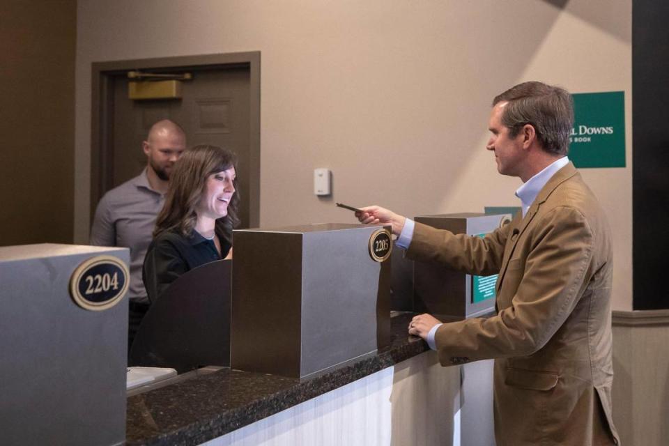 Kentucky Gov. Andy Beshear places the state’s first legal sports wager at Churchill Downs on Thursday with mutuels manager Kristina McManigell. Sports betting is now legal at nine outlets across the state. Online wagering in Kentucky will get underway Sept. 28.