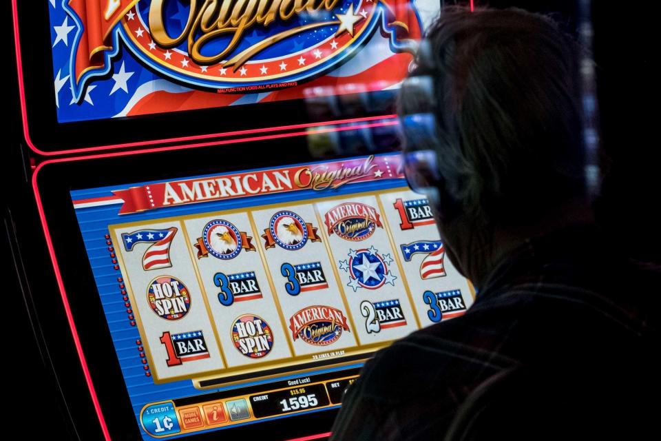 A man plays a video slot machine in a lounge at Huck's, a truck stop in Mount Vernon, Illinois.