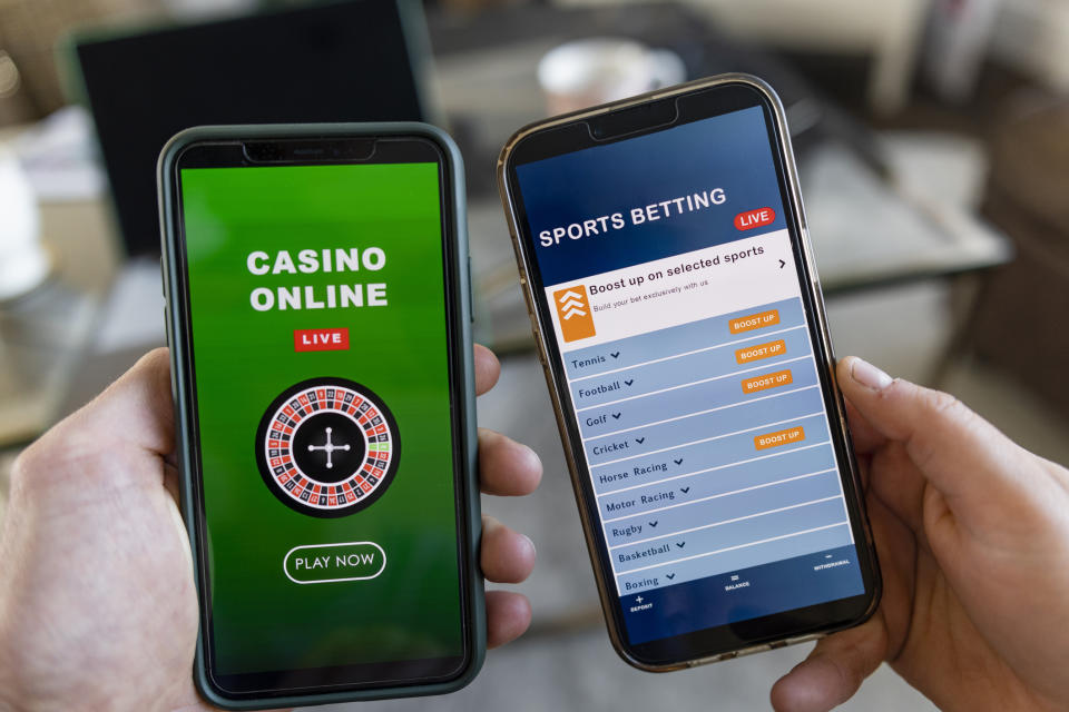 Two smartphones showing online gambling apps: one with a casino game interface and the other with a sports betting menu