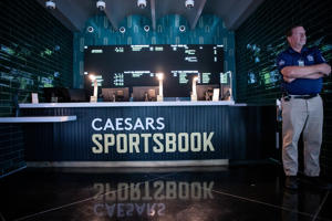 A security guard stands in front of one of the betting windows on the second floor of the Caesars Sportsbook at Chase Field in Phoenix on June 21, 2022.