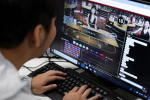 A screen shows Oriental Game, licensed to run an online gambling website in the Philippines, which has a live platform on its website for customers to interact with the young, female Chinese dealers. Photo: SCMP