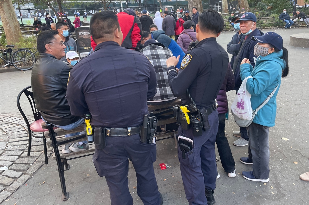 NYPD officers stare on a gambling ring in Columbia park.