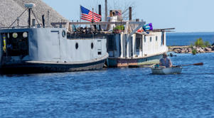 A man rows a boat on the lower Menominee River in Marinette in August. The EPA is delisting the lower Menominee River after nearly 30 years of cleanup to remove contamination at risk of flowing into the Great Lakes.