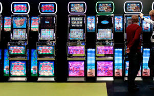 Men gamble on slot machines - SHAUN CURRY/AFP