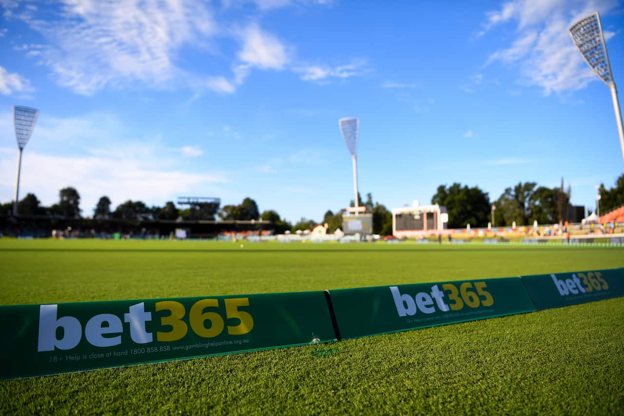 Betting adverts on the boundary rope at an oval.