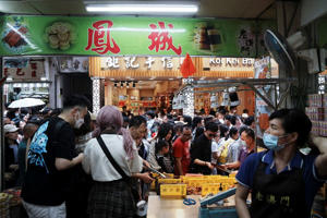 Visitors walk past the Feng Cheng Recordacao Macau during Labour Day holiday in Macau