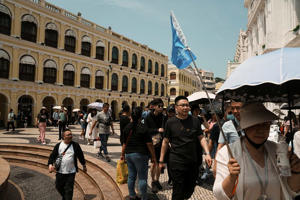 Visitors walk past the Municipal Affairs Bureau during Labour Day holiday in Macau