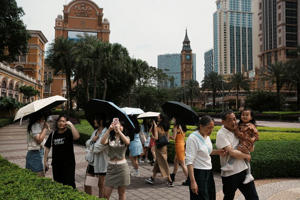 Visitors take pictures in front of a replica of Big Ben at the Londoner Macao casino resort, which is operated by Sands China, during Labour Day holiday in Macau