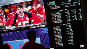 A person gambles as betting odds for the Super Bowl are displayed on monitors at the Circa resort and casino sports book Friday, Feb. 3, 2023, in Las Vegas.