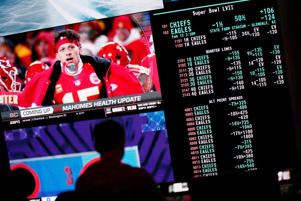 A person gambles as betting odds for NFL football's Super Bowl are displayed on monitors at the Circa resort and casino sports book Friday, Feb. 3, 2023, in Las Vegas.