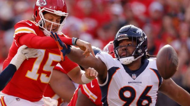 Eyioma Uwazurike of the Denver Broncos reaches out to block Kansas City Chiefs quarterback Patrick Mahomes