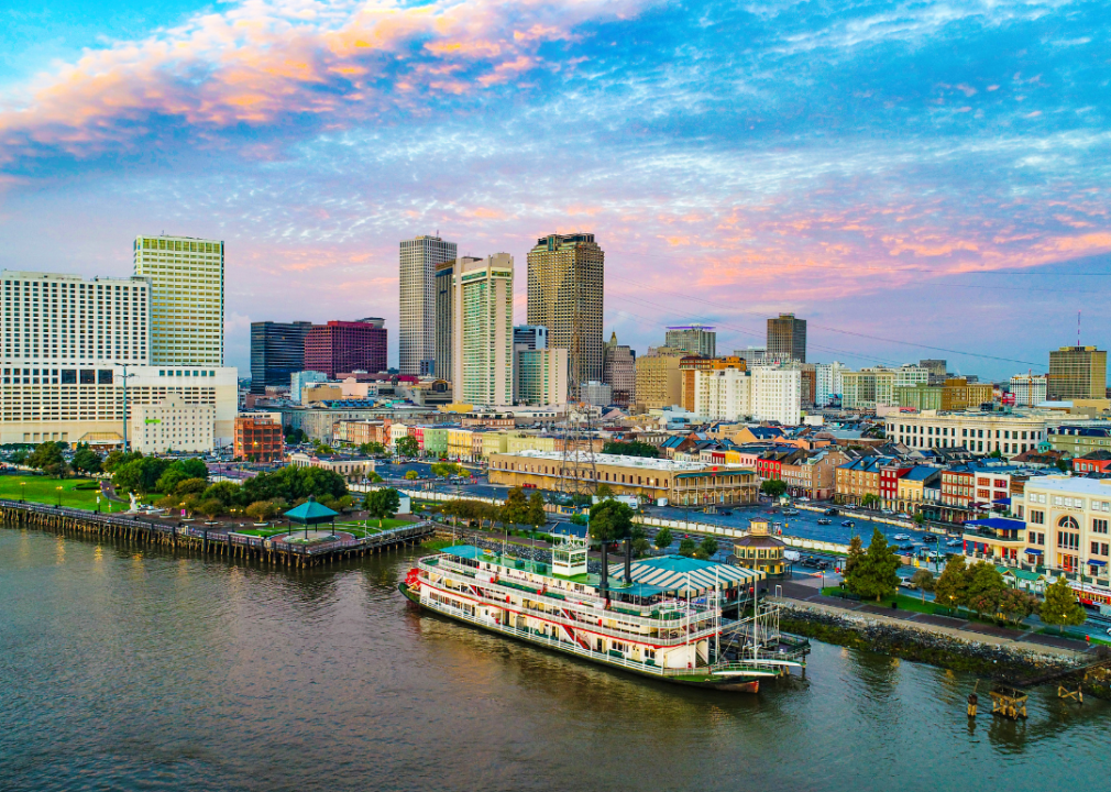 A boat on the water with the New Orleans skyline in the background.