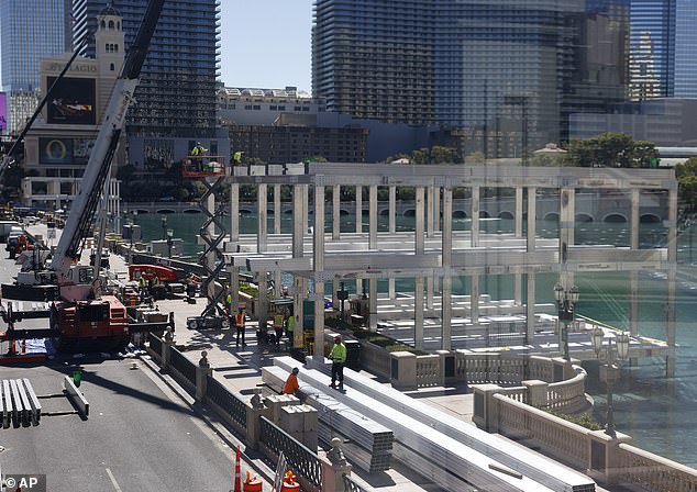 Workers stand at a Formula One construction site at the Bellagio fountains on Monday, Sept. 25, 2023