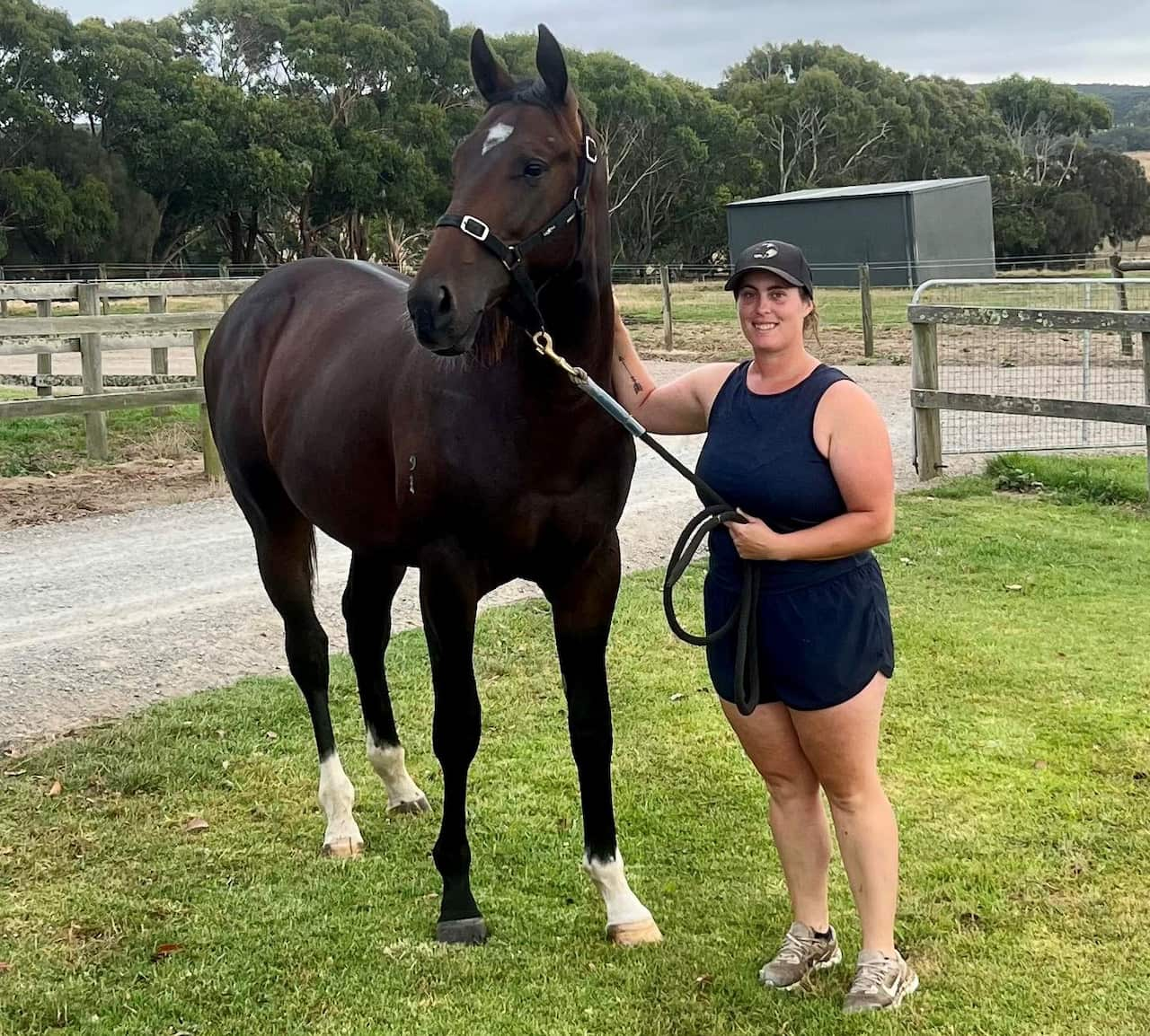 A woman standing next to a horse.