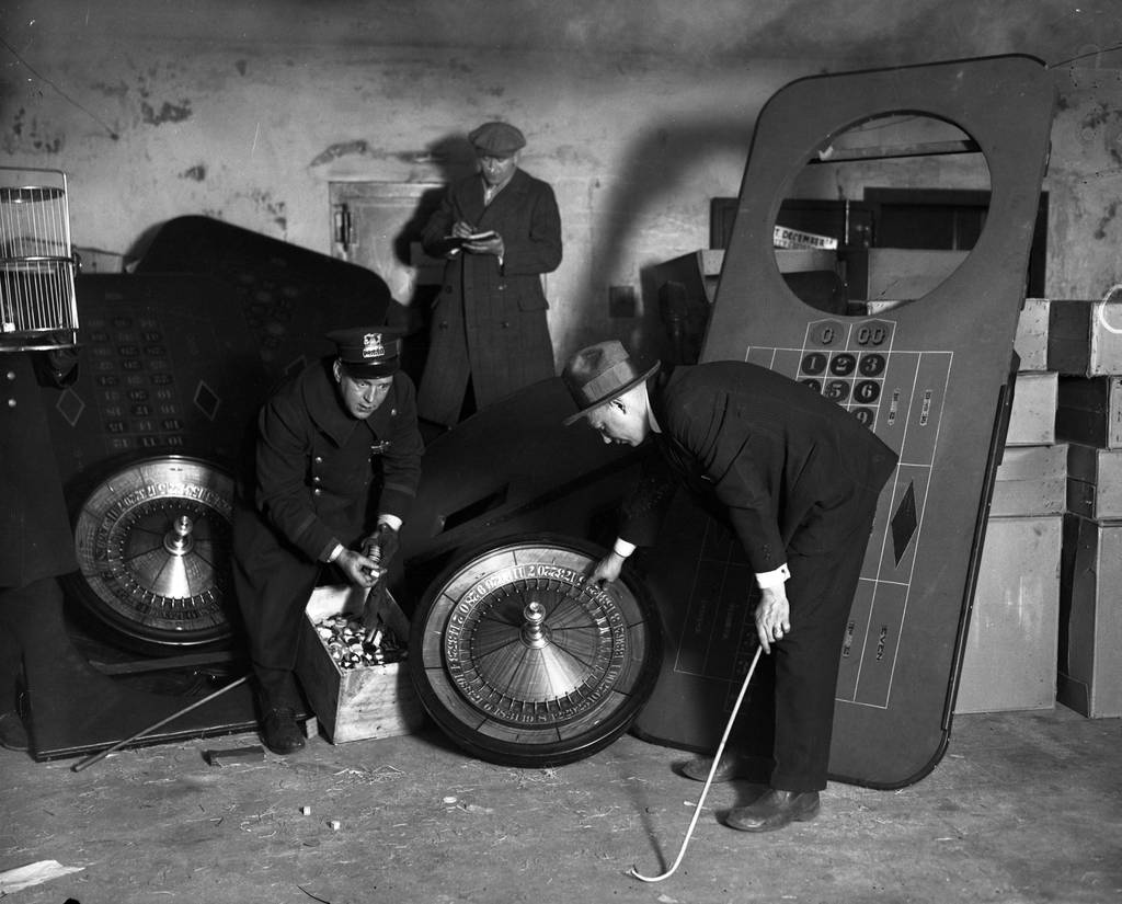 Officers show off the gambling paraphernalia found during a raid of The Ship, circa 1927. 