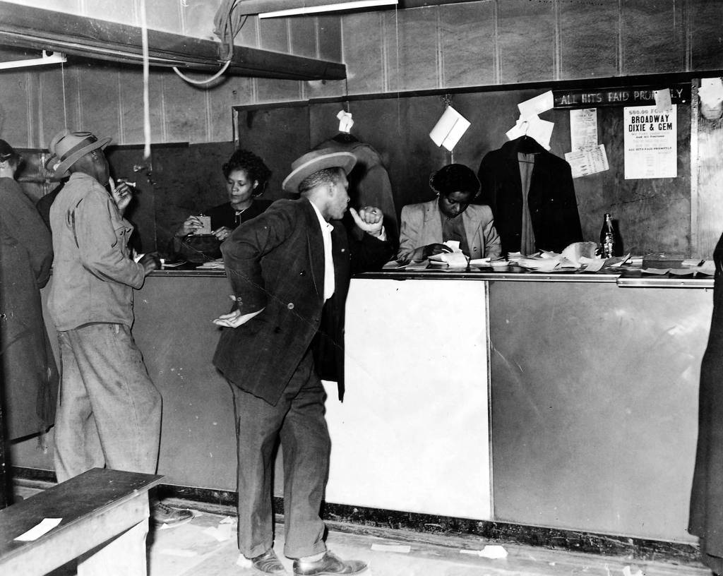 In 1949 female clerks, who were eventually arrested, sell numbers for the policy game to customers just before a police raid at 610 E. 50th St. in Chicago.