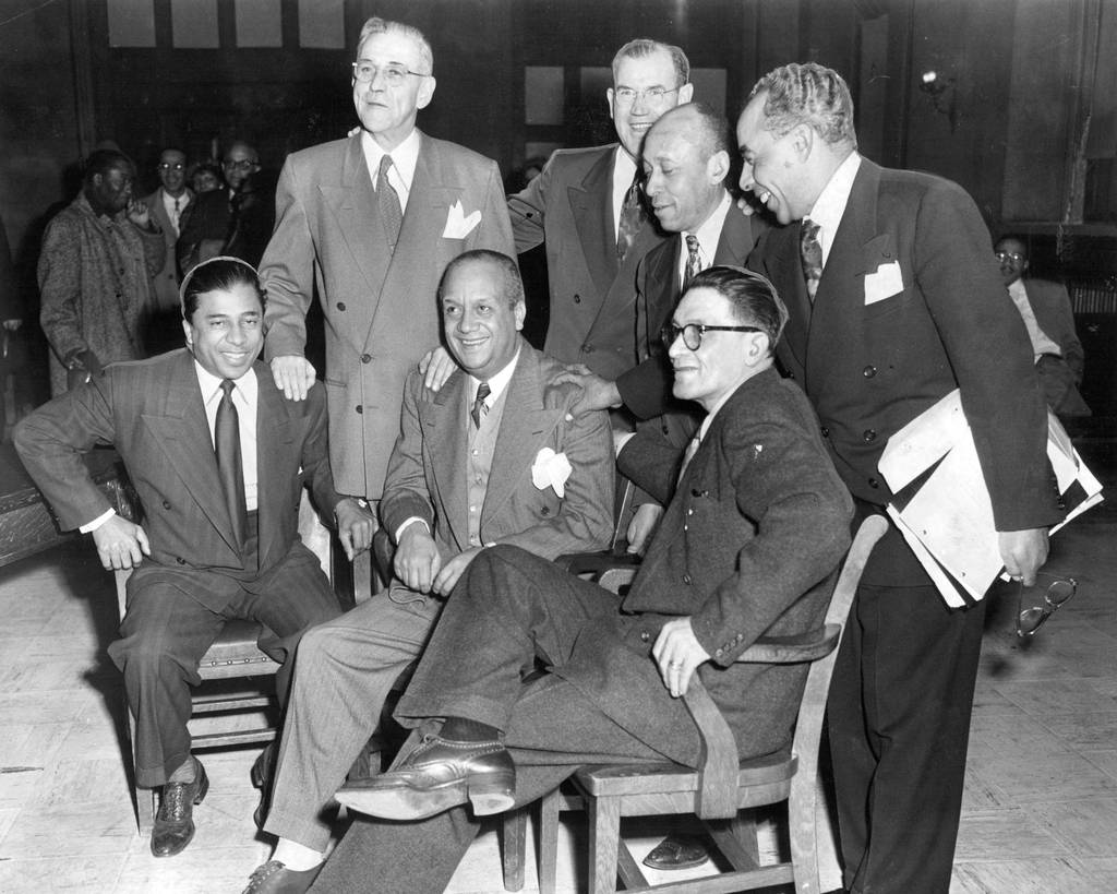 Clifford Davis, seated from left, Edward Jones and Theodore Roe were found not guilty in the policy racket on Feb. 5, 1952. The three policy chiefs were accused of a gambling conspiracy and were freed on directed verdict. Their attorneys are behind them. 