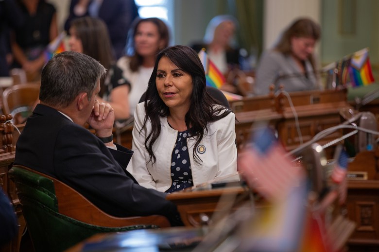 Assemblymember Blanca Rubio, a Democrat from Los Angeles, talks to a colleague at the state Capitol in Sacramento on Aug. 17, 2023. Photo by Semantha Norris, CalMatters