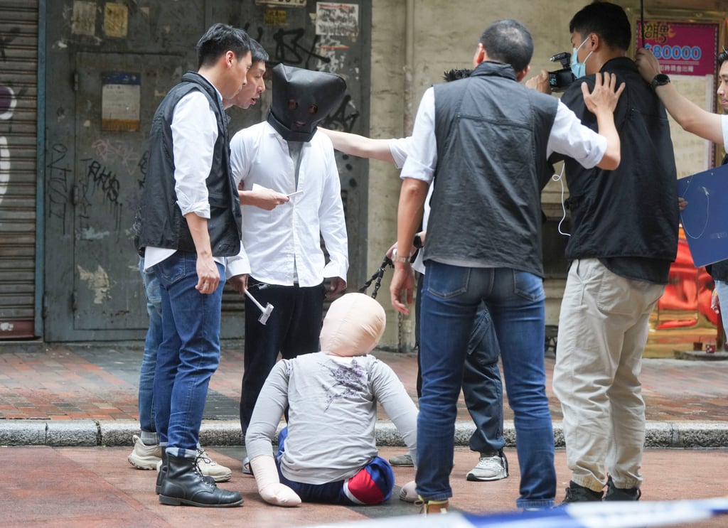 Suspect takes part in police re-enactment of fatal hammer attack in Hong Kong