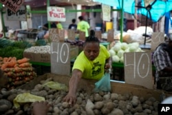 Ever Martinez sells potatoes at a flea market in Maracaibo, Venezuela, July 22, 2024.