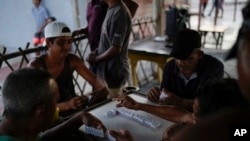 People play dominoes in the Santa Rosa de Agua neighborhood of Maracaibo, Venezuela, July 22, 2024.