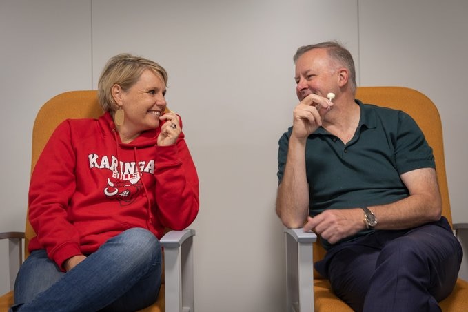 Peta Murphy and Anthony Albanese eat lollypops after receiving vaccines