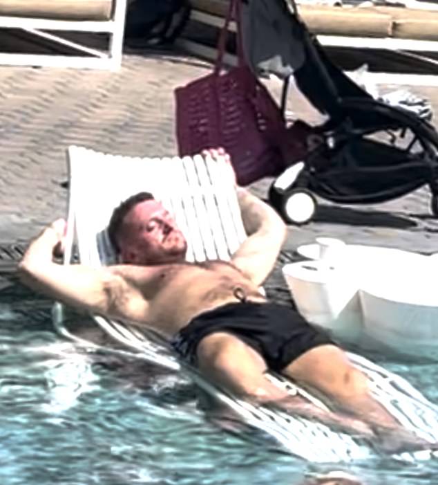 Tommy Robinson is seen resting and relaxing on a sunlounger in a pool while inciting violence at home