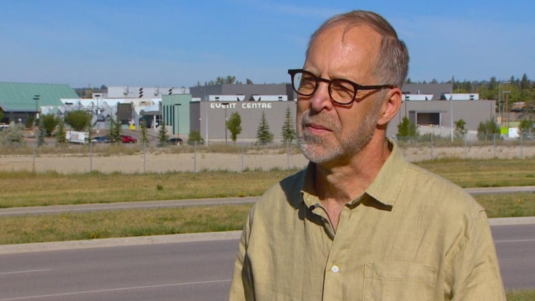 A man stands in front of a casino.