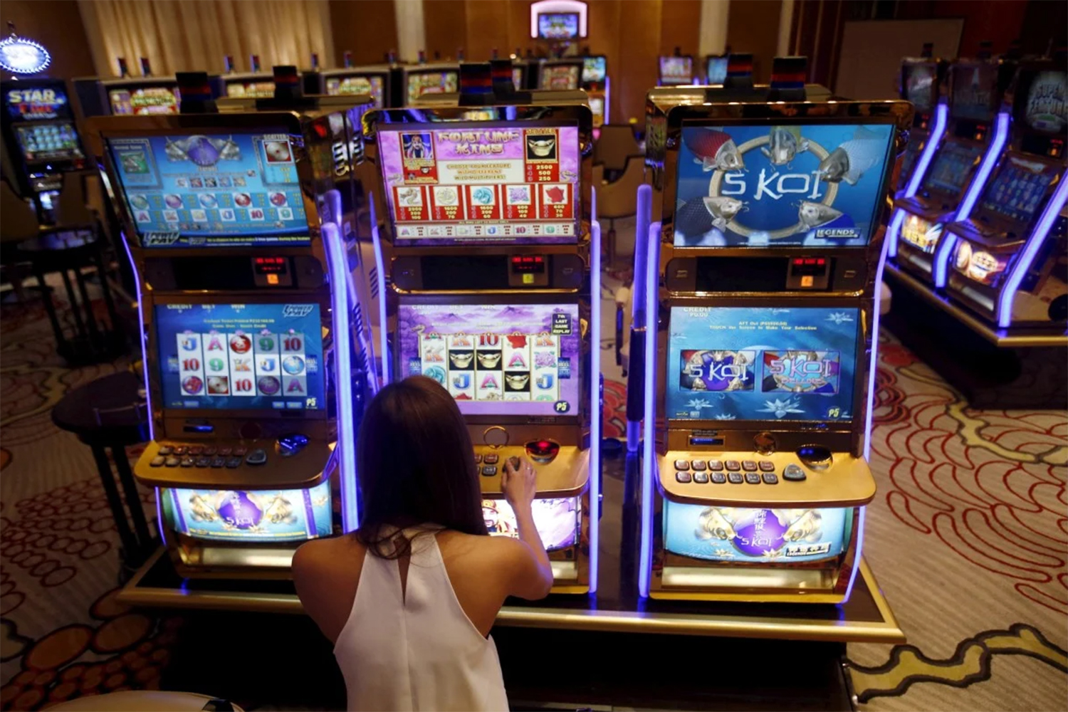 A happy woman plays a digital slot machine at a casino. (Photo: South China Morning Post)