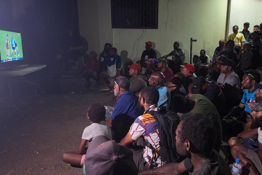 a group watches the NRL state of origin at night