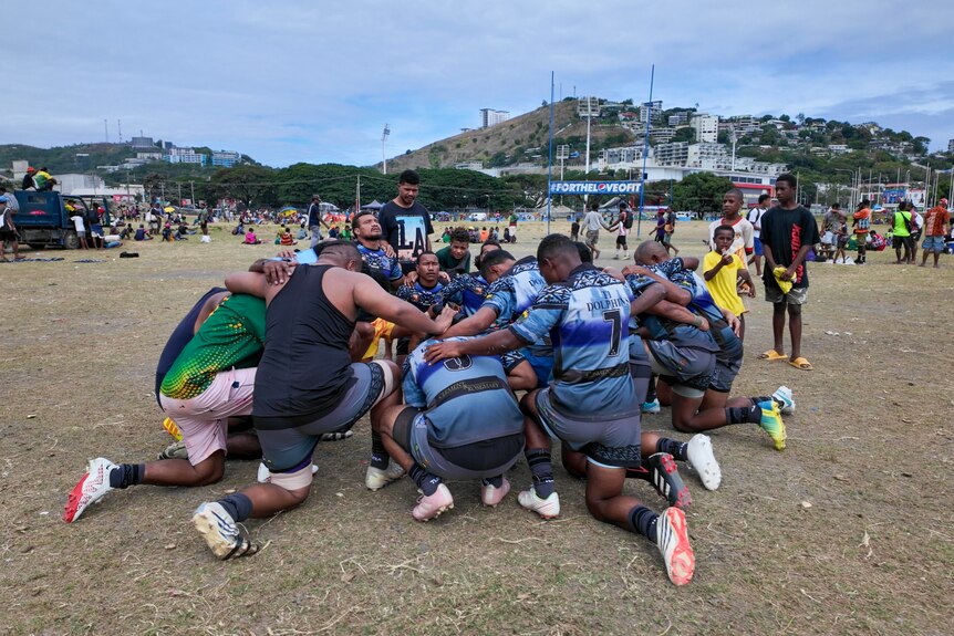 a team pray on a rugby league field