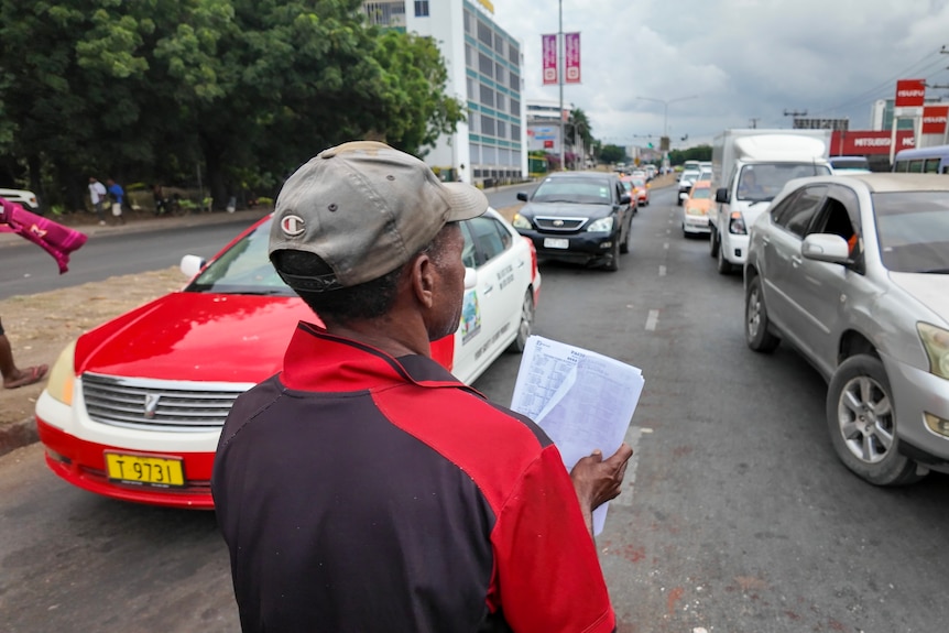 a man in a red shirt holds a guide