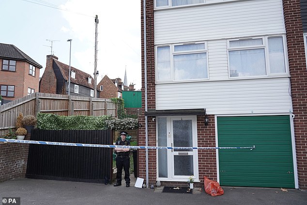 A police officer stands guard outside the house after McCullough was arrested. She confessed to the crime on the spot