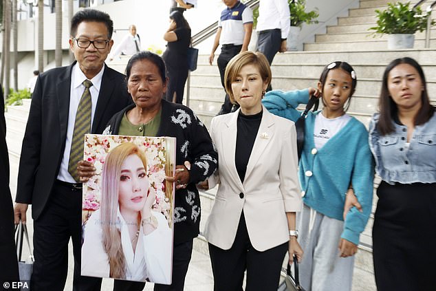 Thongpin Kiatchanasiri, mother of Siriporn 'Koy' Khanwong, holds a picture of her daughter, who was poisoned by  Sararat Rangsiwuthaporn, outside the Criminal Court in Bangkok, Thailand today